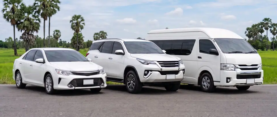 รถเก๋ง SUV และรถตู้ติดป้าย TAXI บนหลังคา จอดบนทางหลวงเส้นตรงกลางทุ่งนา
