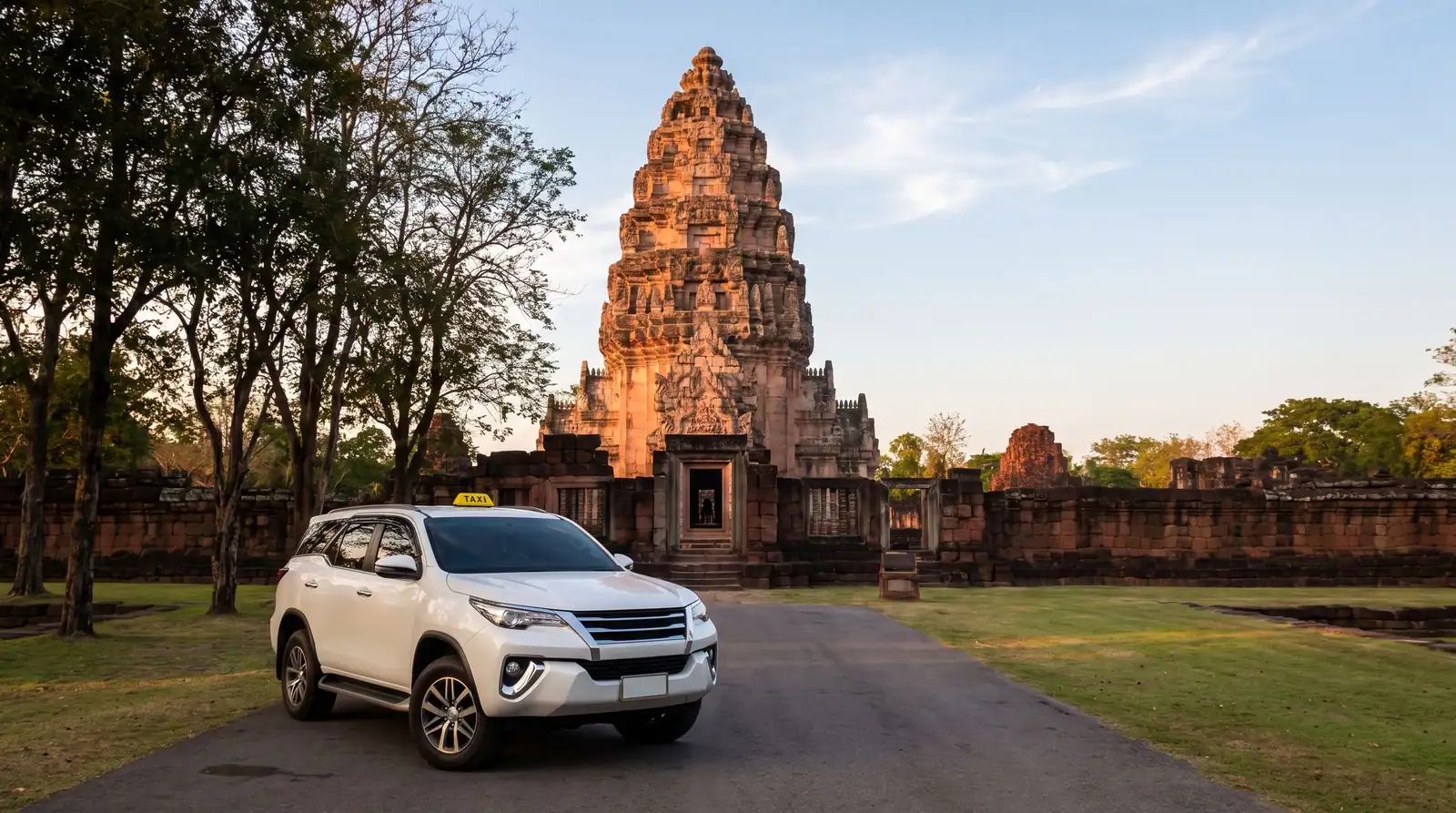 ปรางค์หินทรายพิมายยามเย็น กับแท็กซี่ SUV สีขาวบนถนนทางเข้า